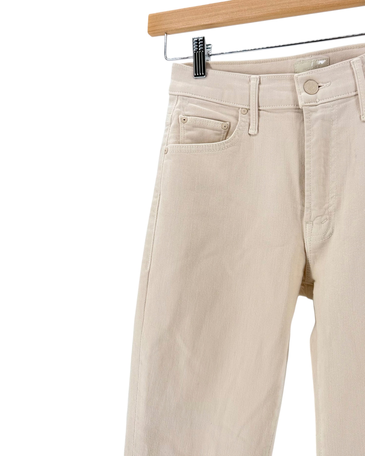 Light beige cream denim jeans on a hanger on a white background