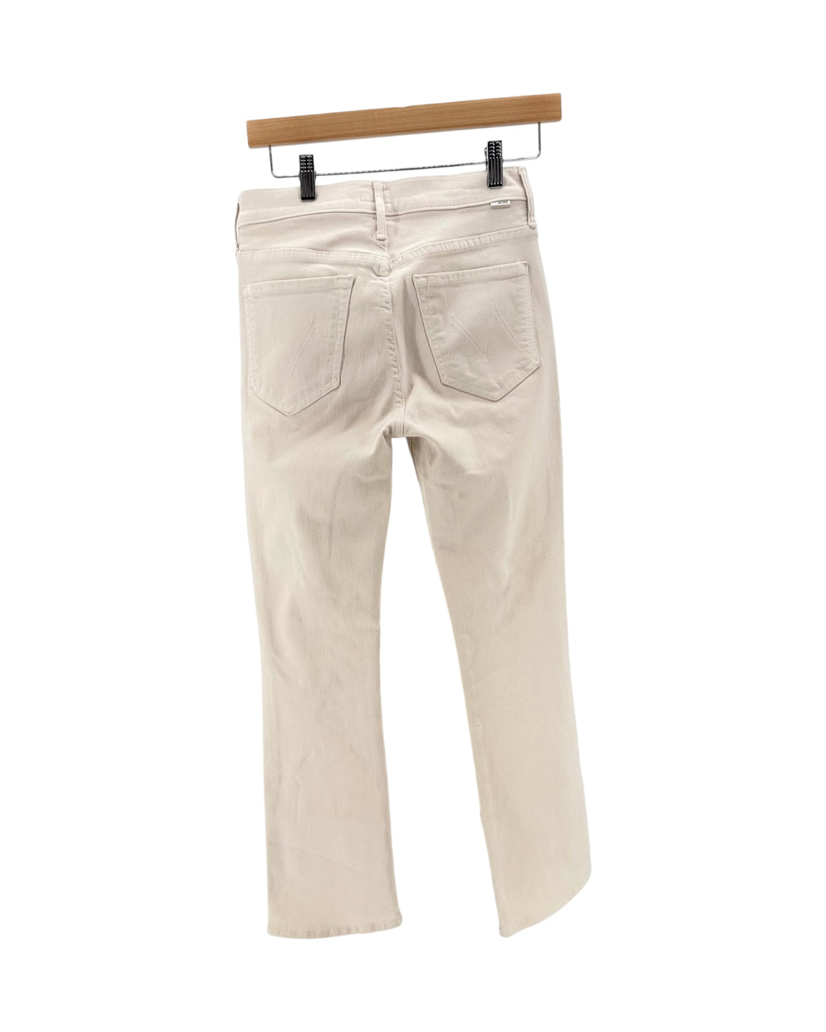 Light beige cream denim jeans on a hanger on a white background