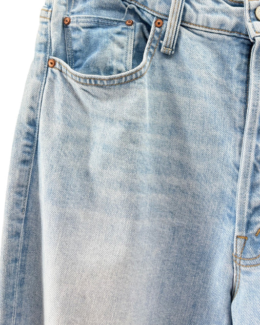 Close-up of light blue denim jeans with stitching details.