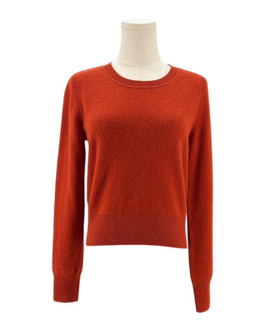 Orange red sweater on a mannequin against a white background
