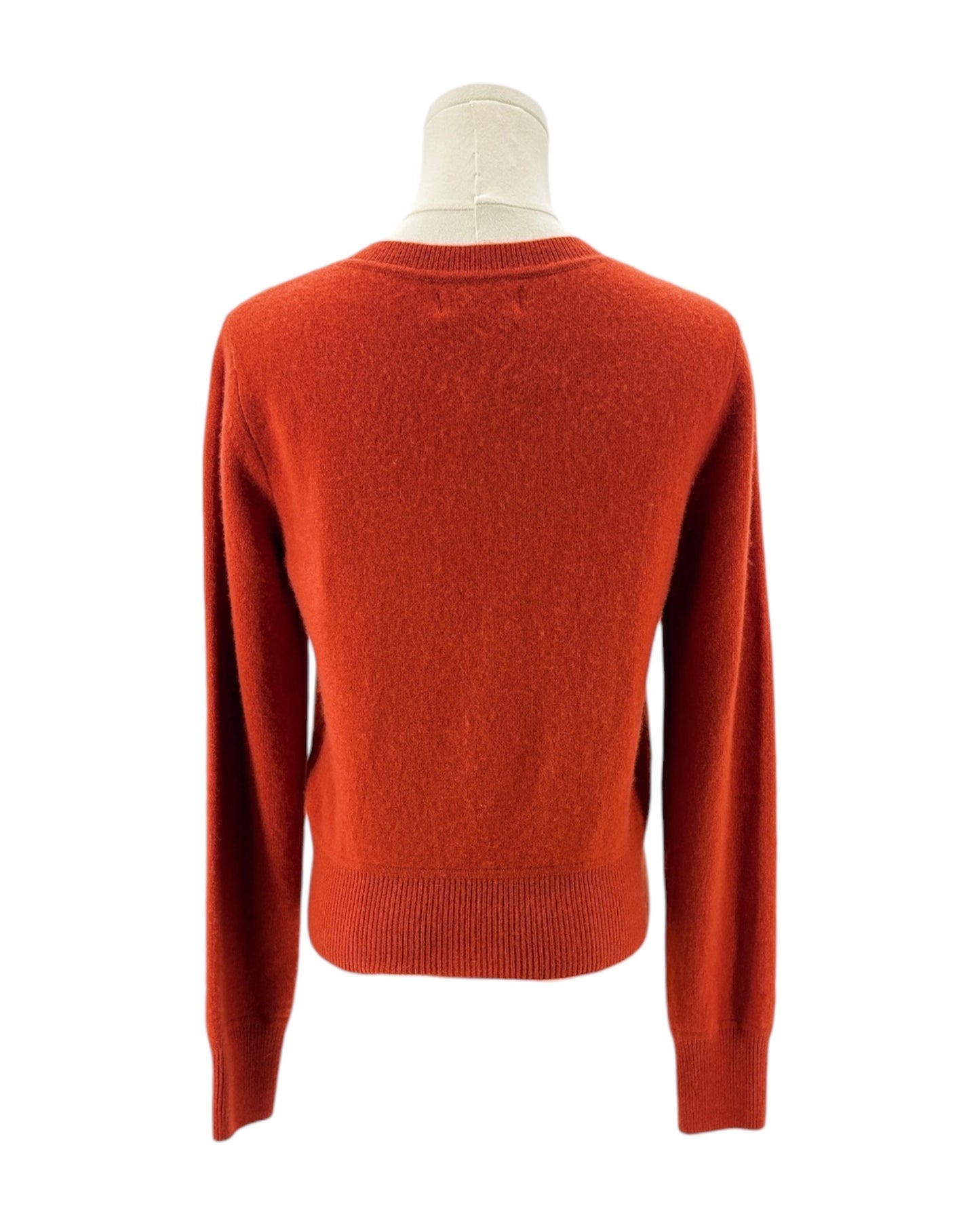 Orange red sweater on a mannequin against a white background