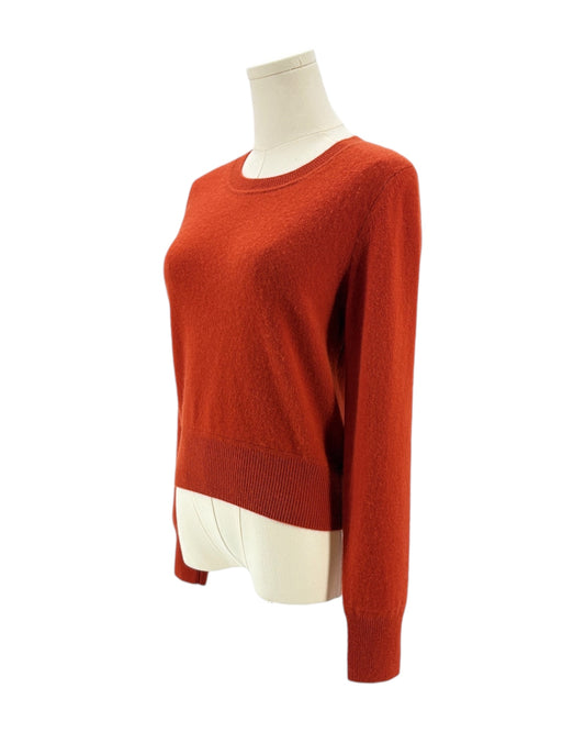 Red orange sweater on a mannequin against a white background