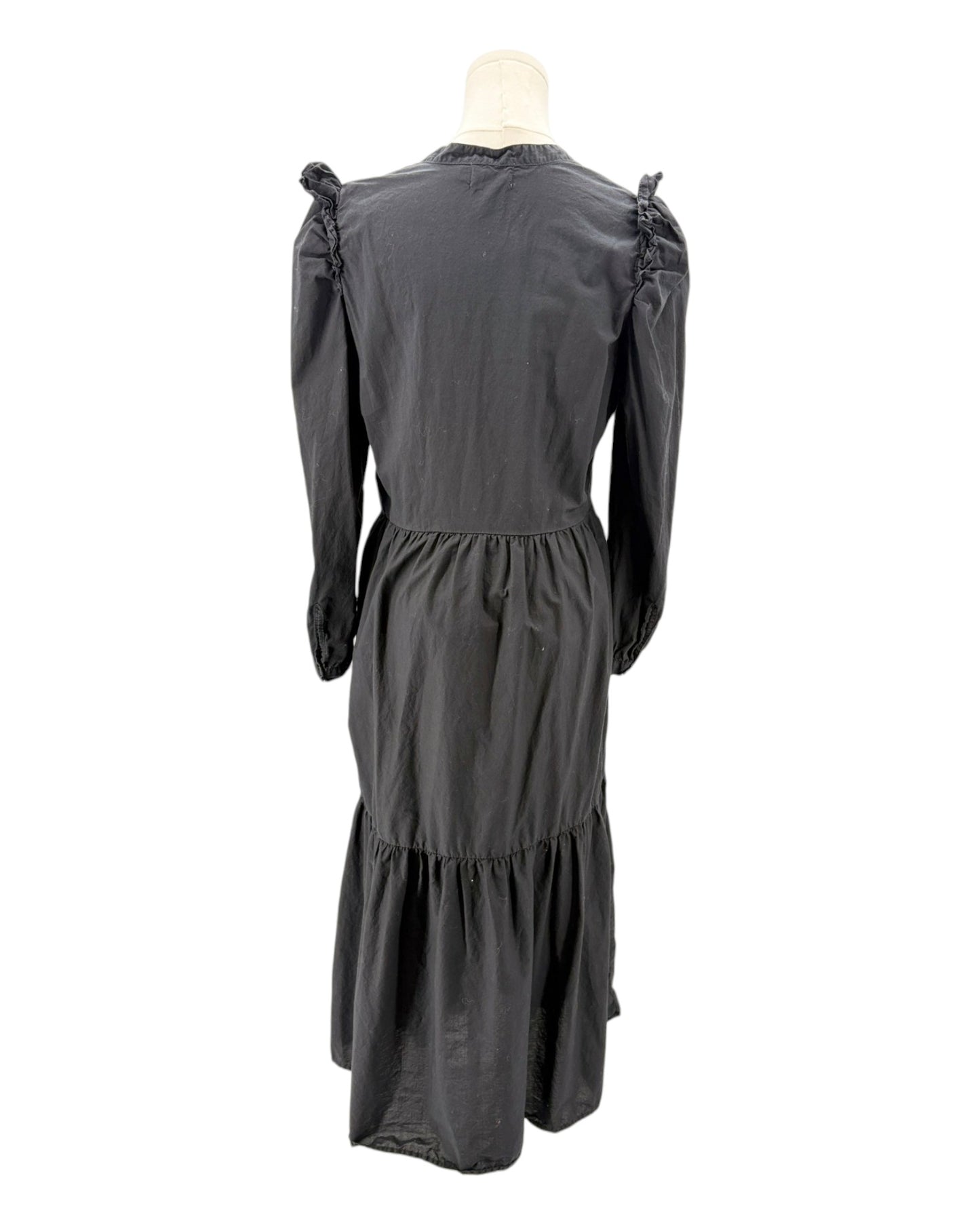 nation LA black dress with ruffled shoulders on a mannequin against a white background