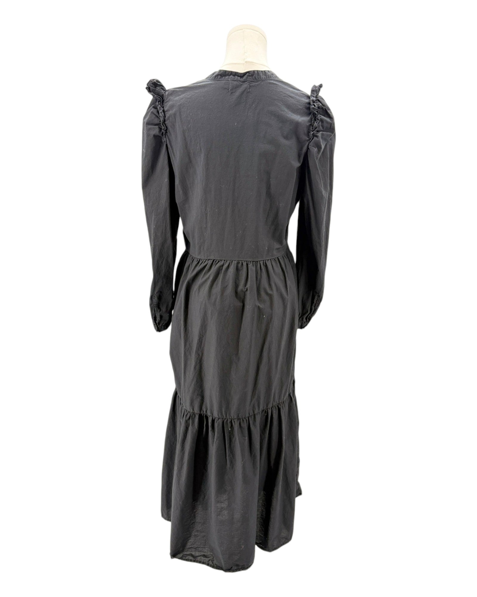 nation LA black dress with ruffled shoulders on a mannequin against a white background