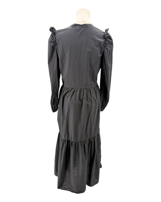 nation LA black dress with ruffled shoulders on a mannequin against a white background