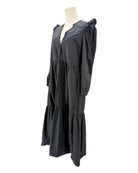 nation LA black dress with ruffled shoulders on a mannequin against a white background