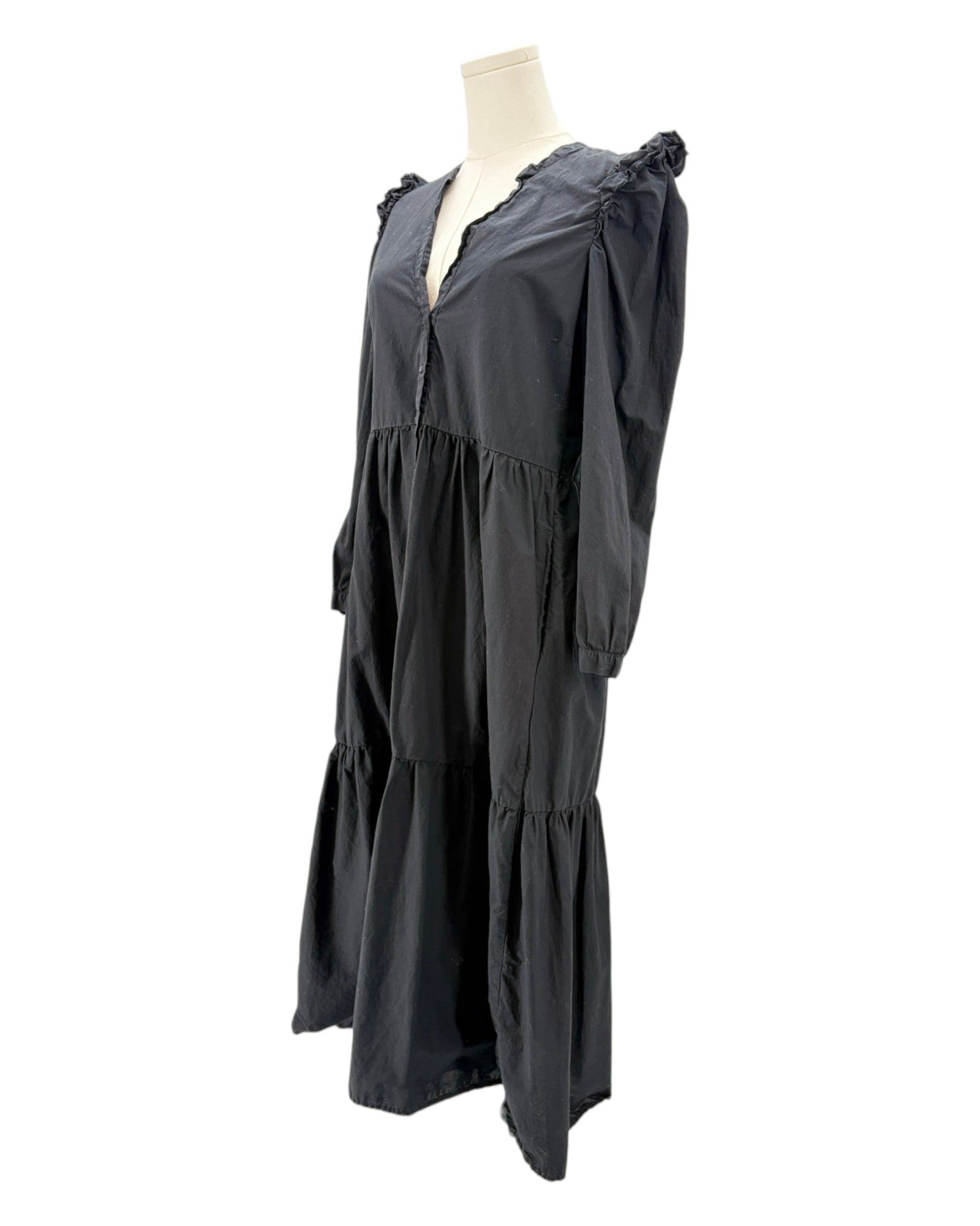nation LA black dress with ruffled shoulders on a mannequin against a white background
