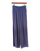 Navy wide-leg pants hanging on a wooden hanger against a white background