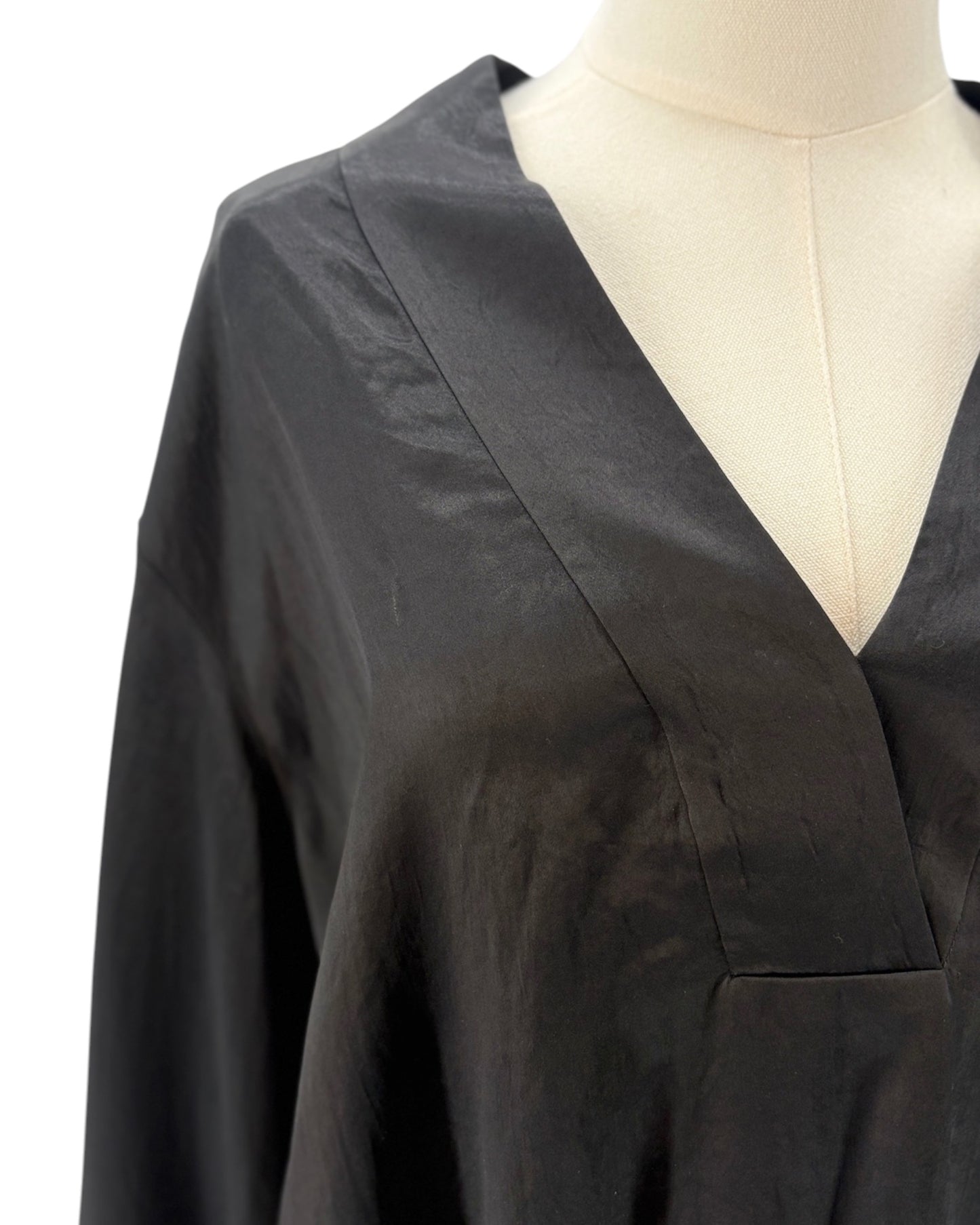 Black blouse on a mannequin with a plain background