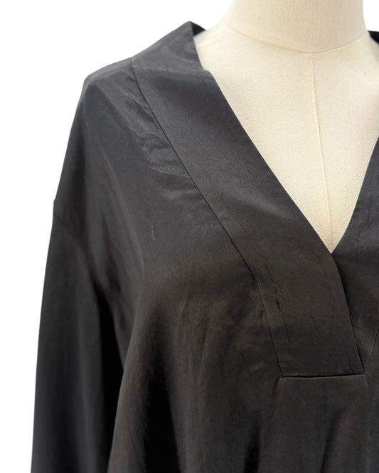 Black blouse on a mannequin with a plain background