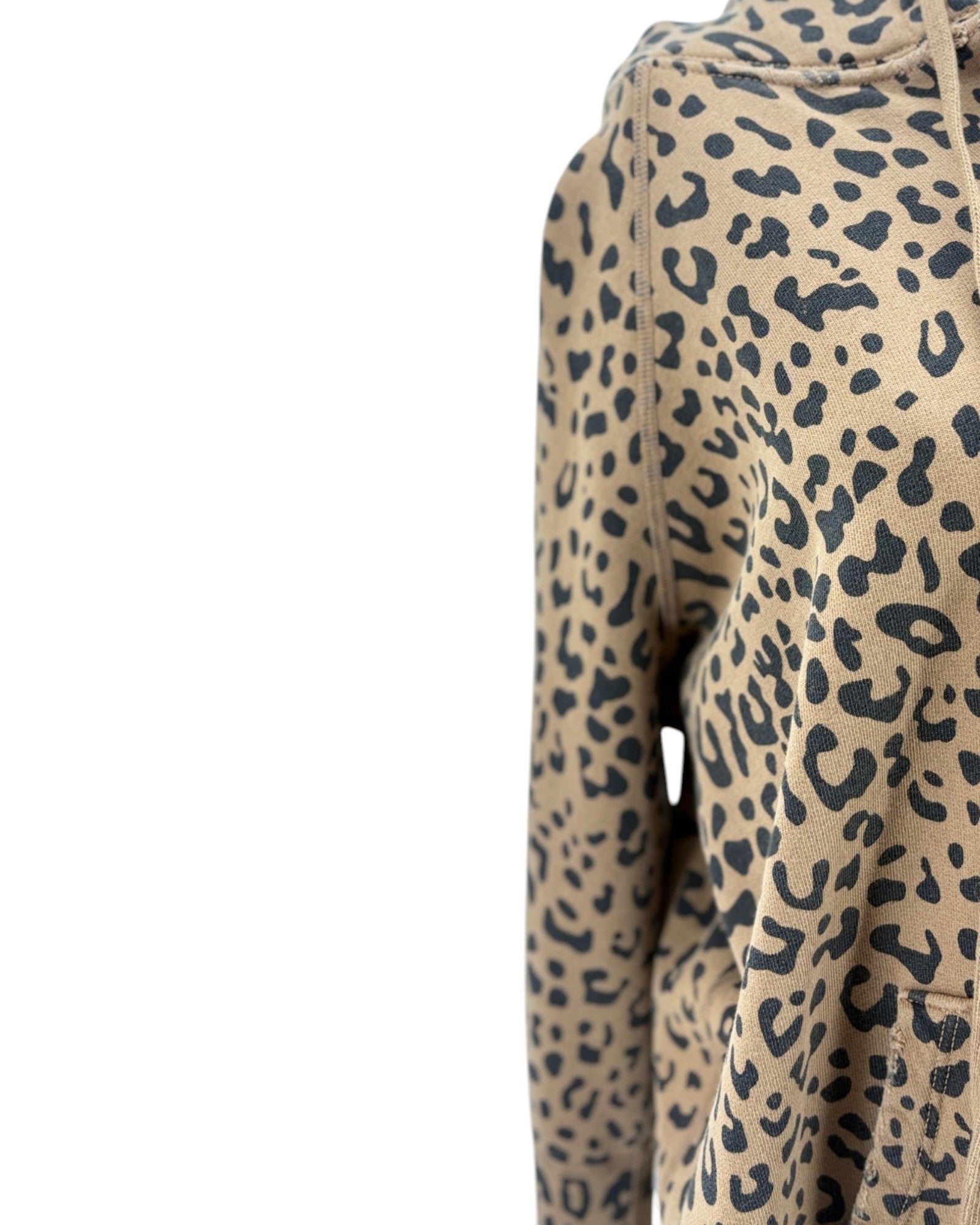 Close-up of a leopard print hoodie on a white background, showing the beige fabric with black spots and part of the hood.