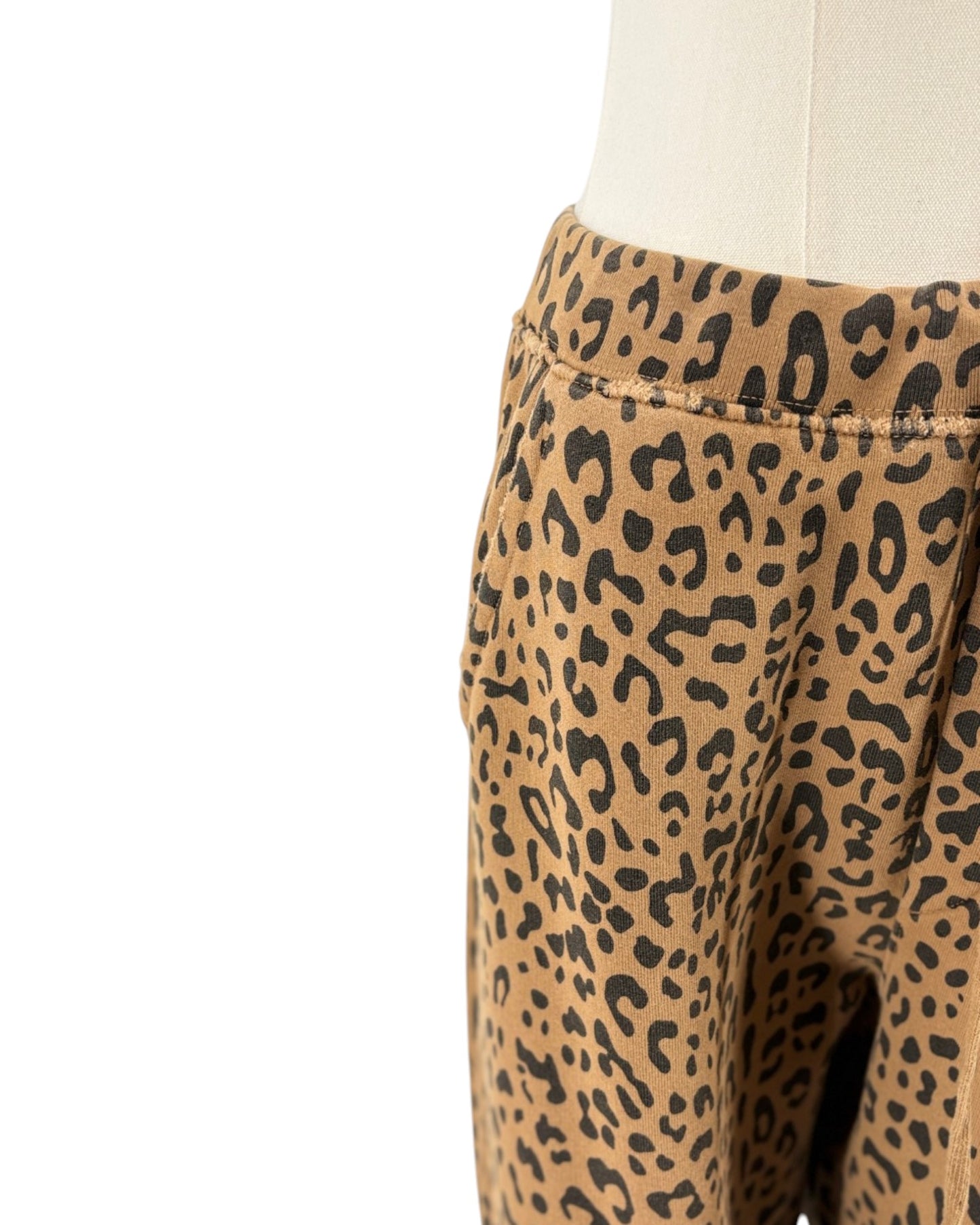 Close-up of leopard-print pants displayed on a cream dress form against a white background.