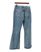 Blue jeans hanging on a wooden hanger against a white background