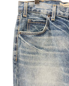 Close-up of a pair of blue jeans with a visible brand label.