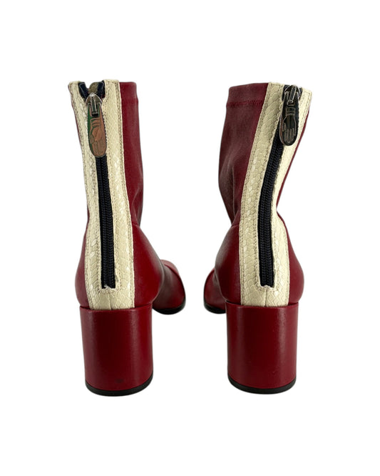 Red boots with a white and beige zipper on a white background