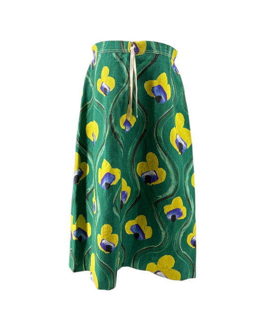 Green skirt with yellow and purple floral pattern on a white background