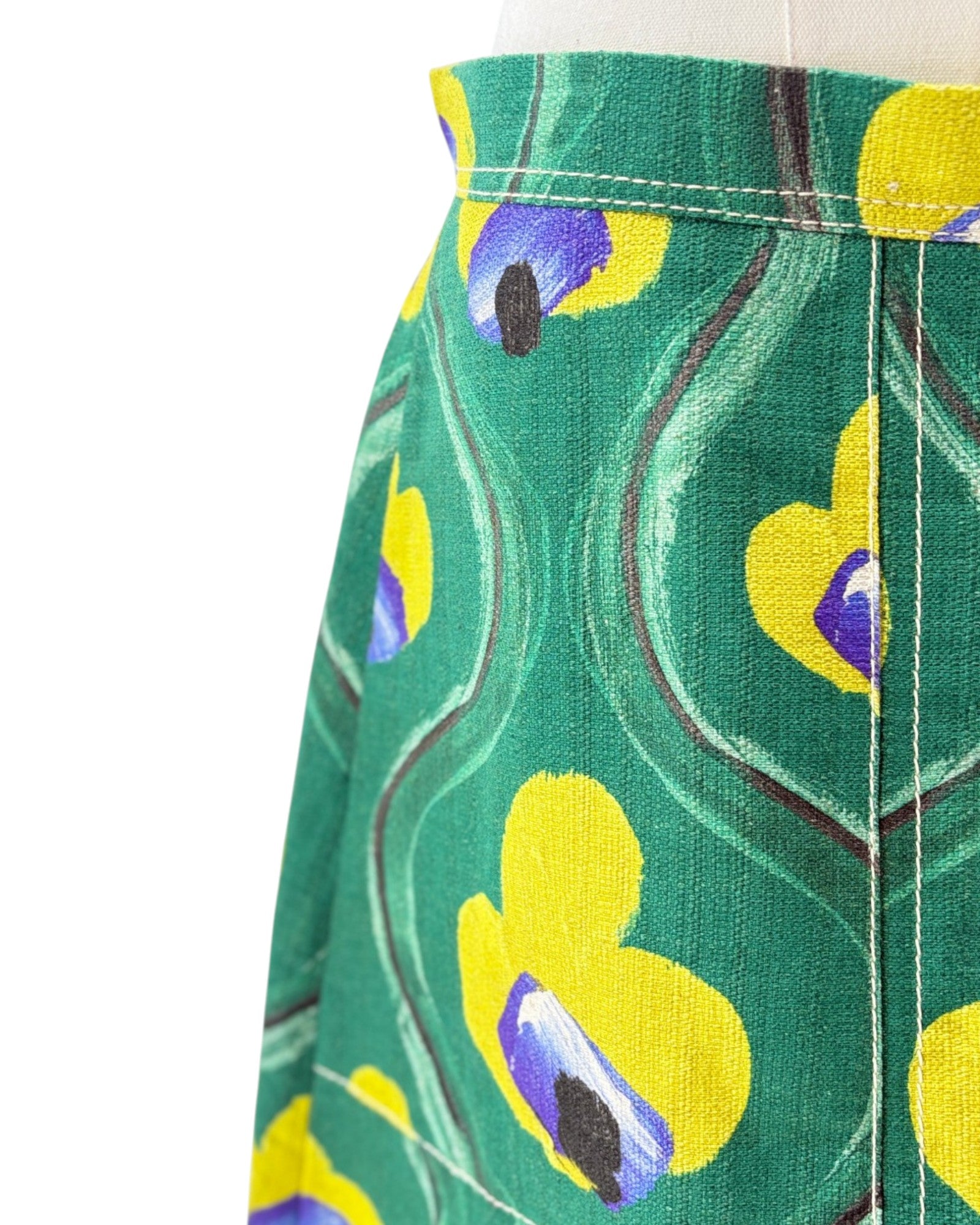 Green skirt with yellow and purple floral pattern on a white background