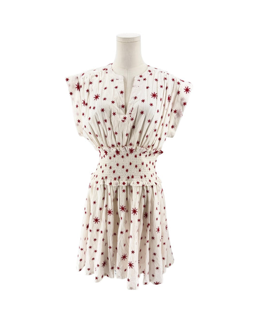 A cream-colored short-sleeve dress with a red starburst pattern, shown from the back on a mannequin against a white background.