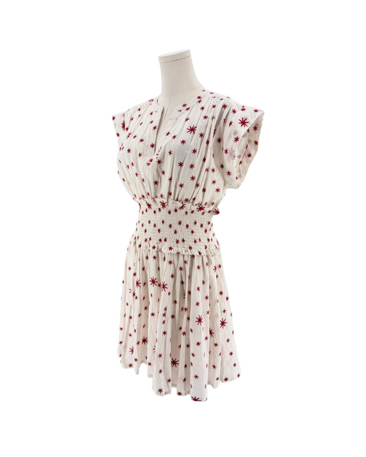 A cream-colored short-sleeve dress with a red starburst pattern, shown from the back on a mannequin against a white background.