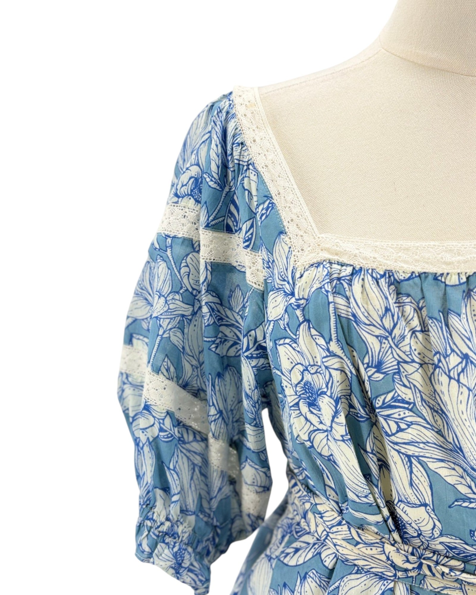 Blue floral dress on a mannequin with a white background