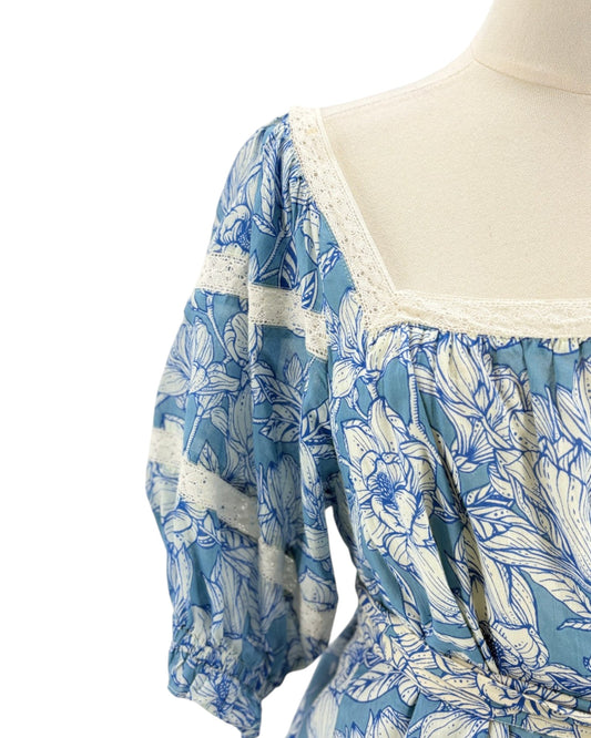 Blue floral dress on a mannequin with a white background