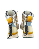 Pair of high-top sneakers with yellow accents and coiled laces on a white background