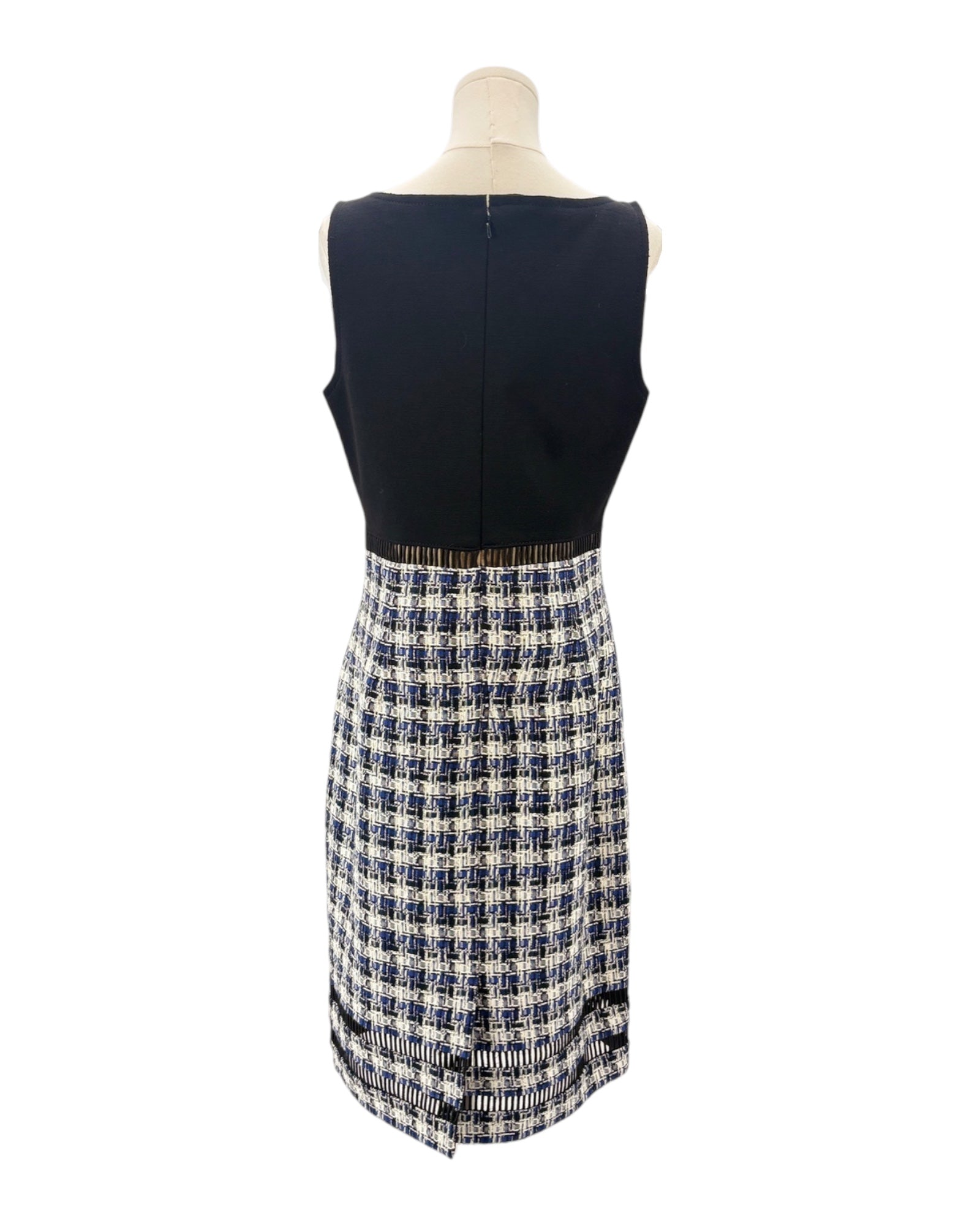 Mannequin wearing a navy sleeveless dress with a tweed plaid skirt on a white background