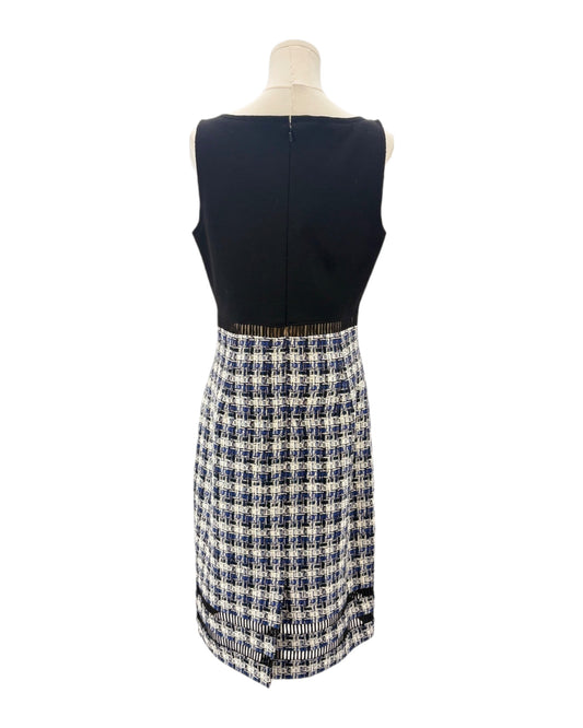 Mannequin wearing a navy sleeveless dress with a tweed plaid skirt on a white background