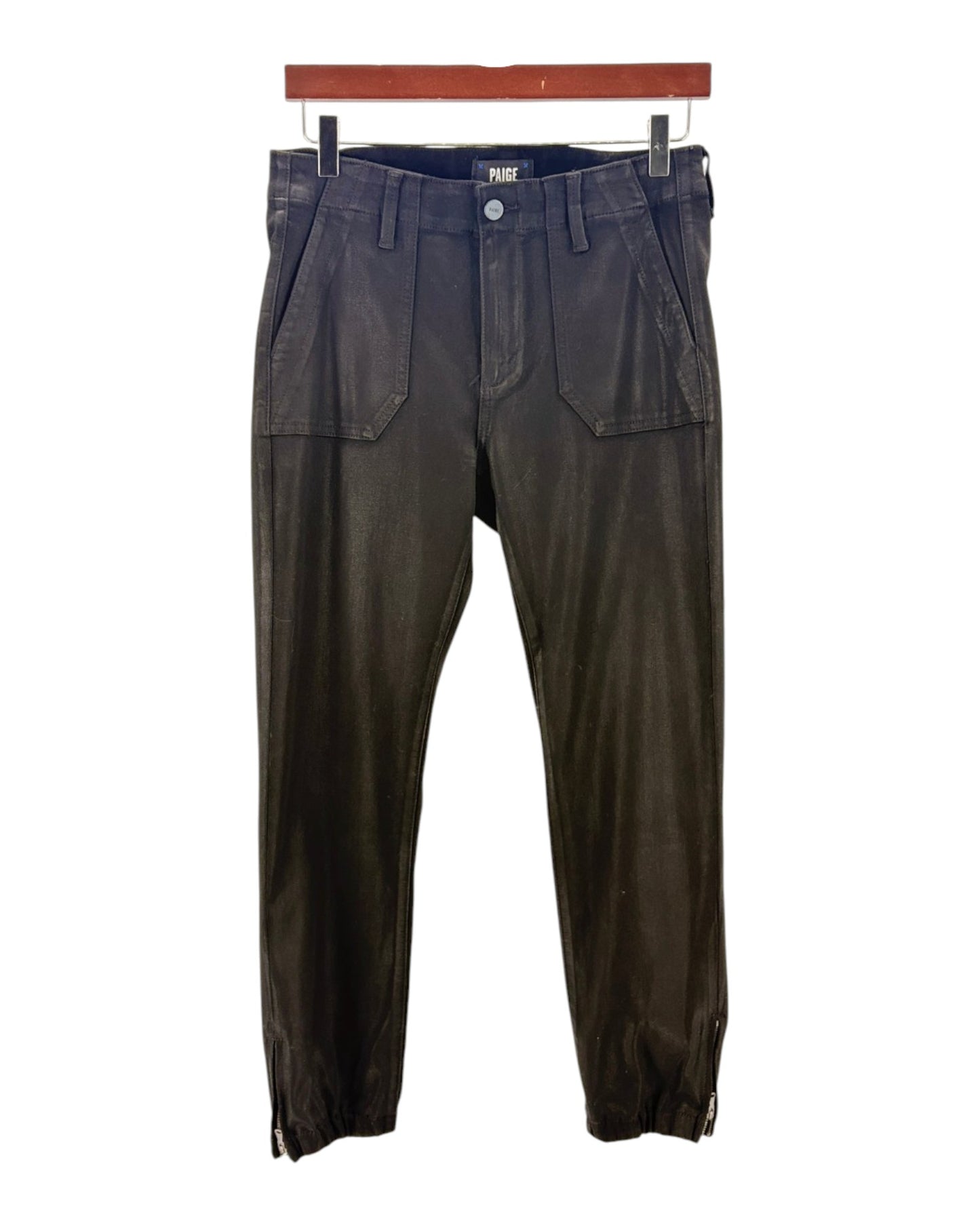 blackpants hanging on a wooden rod against a white background