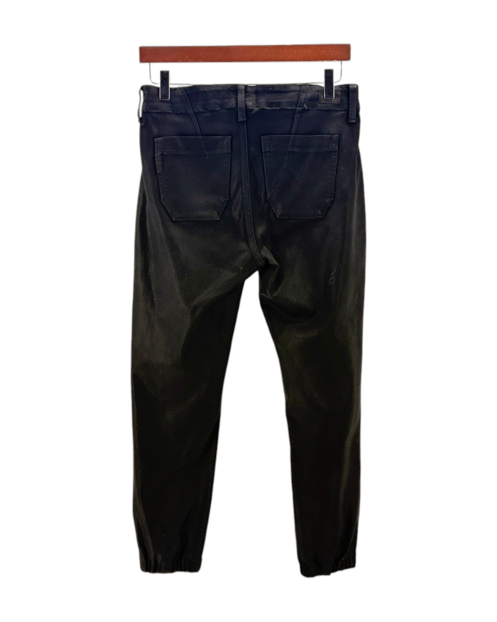 Black coated pants on a hanger against a white background