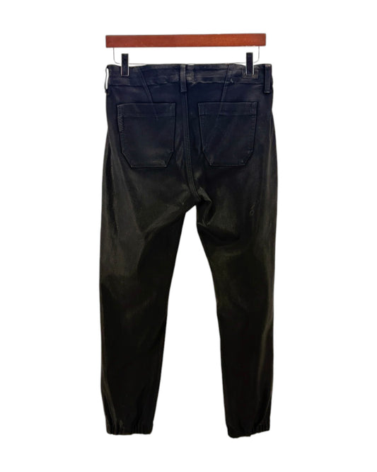 Black coated pants on a hanger against a white background