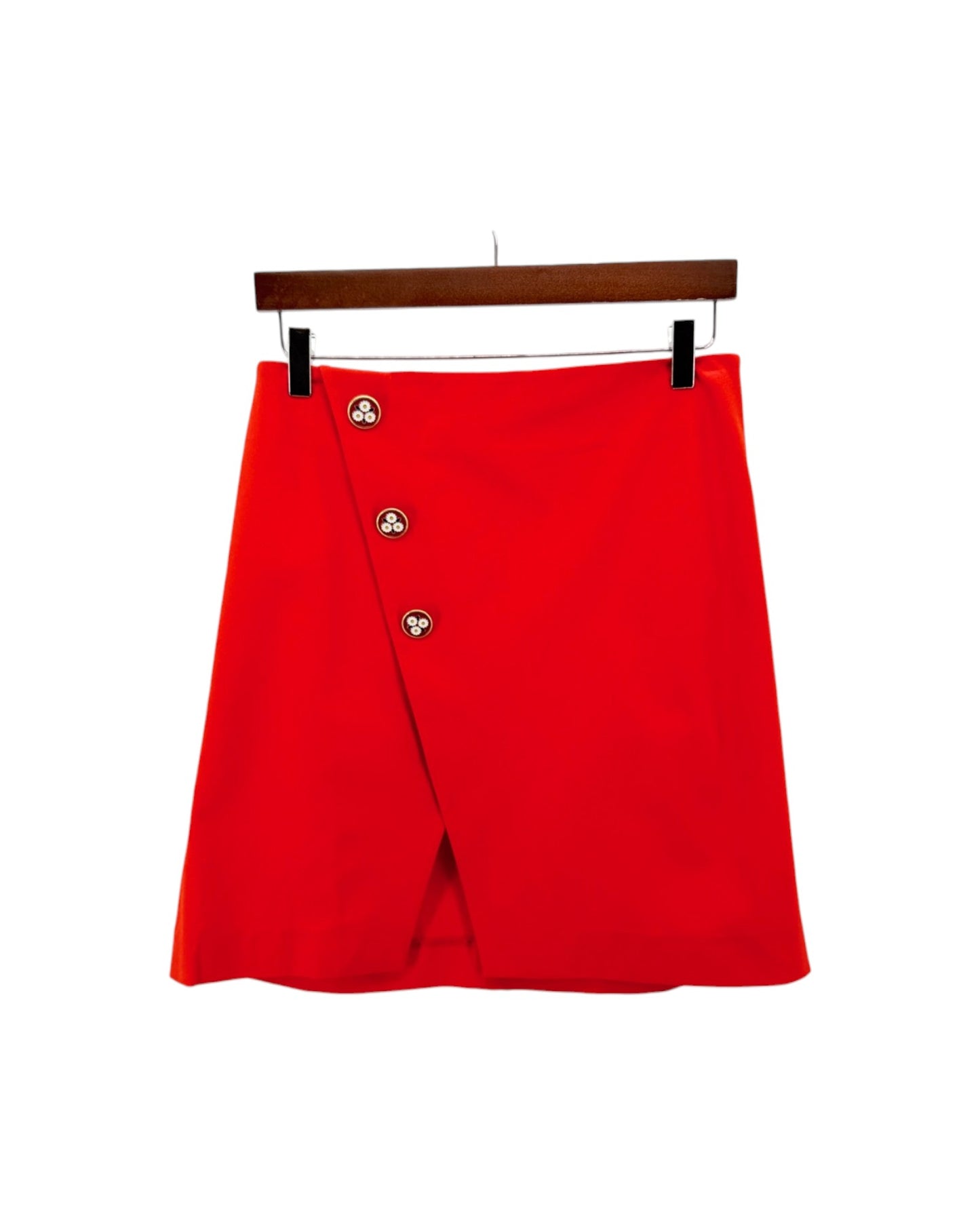 Red skirt on a hanger against a white background