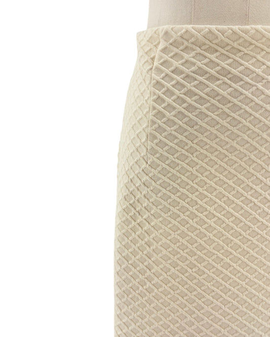 Close-up of a textured beige skirt on a mannequin against a white background