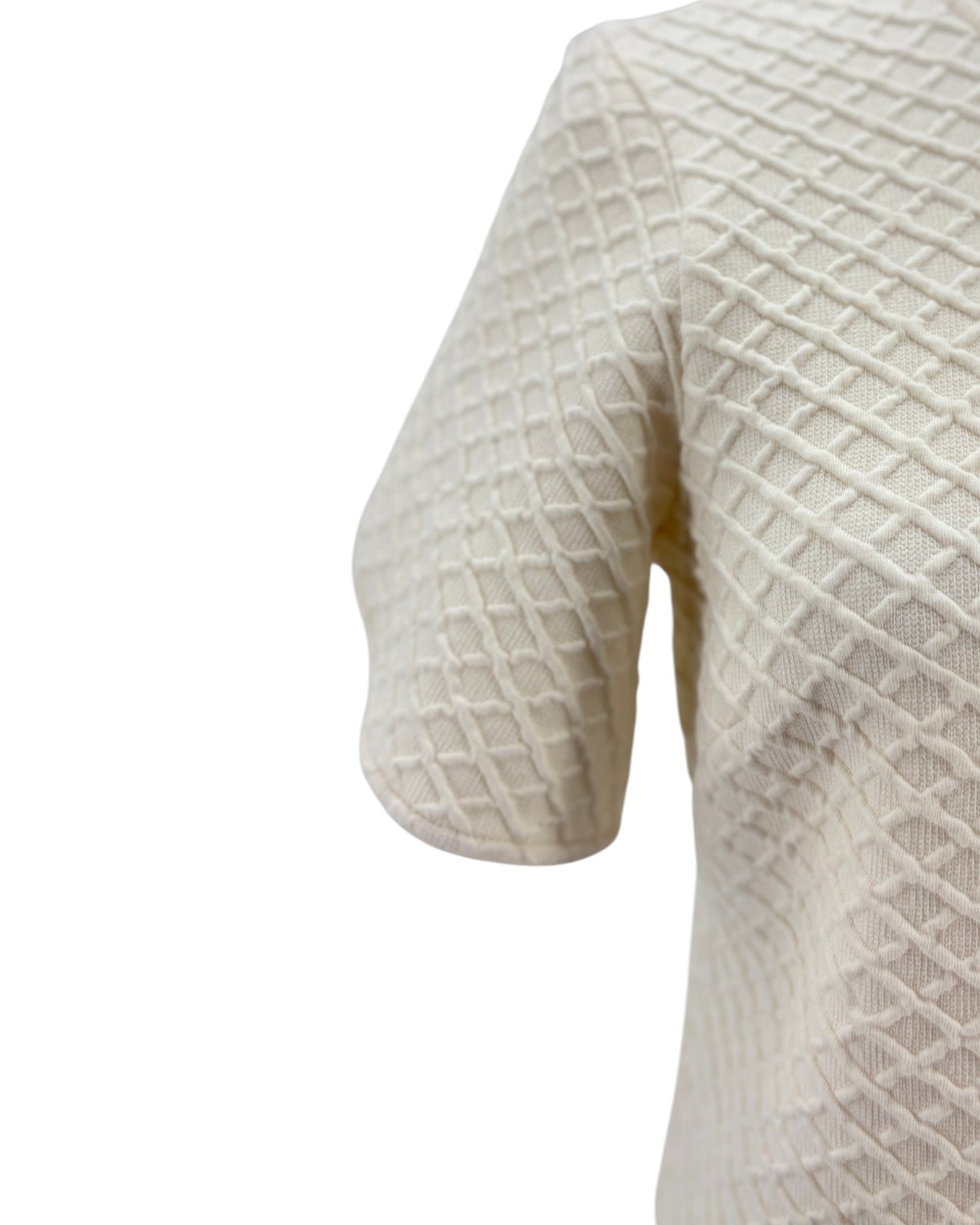 Close-up of a textured white sweater on a white background