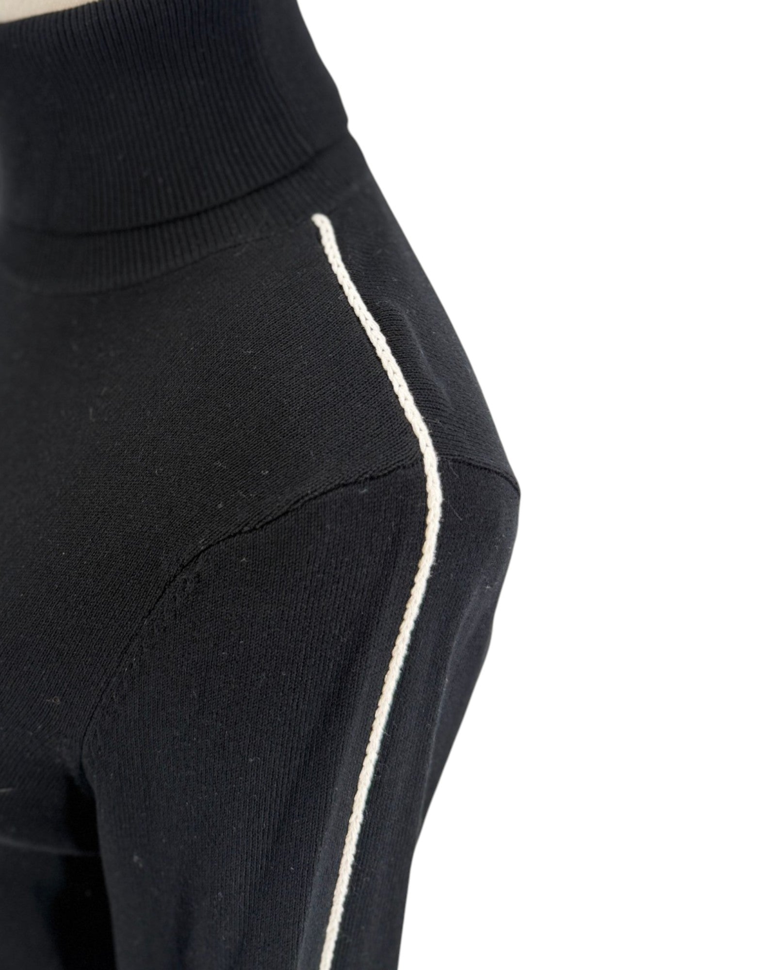 Long sleeve black with a white embroidered strip along the shoulder and sleeve turtleneck sweater on a white background