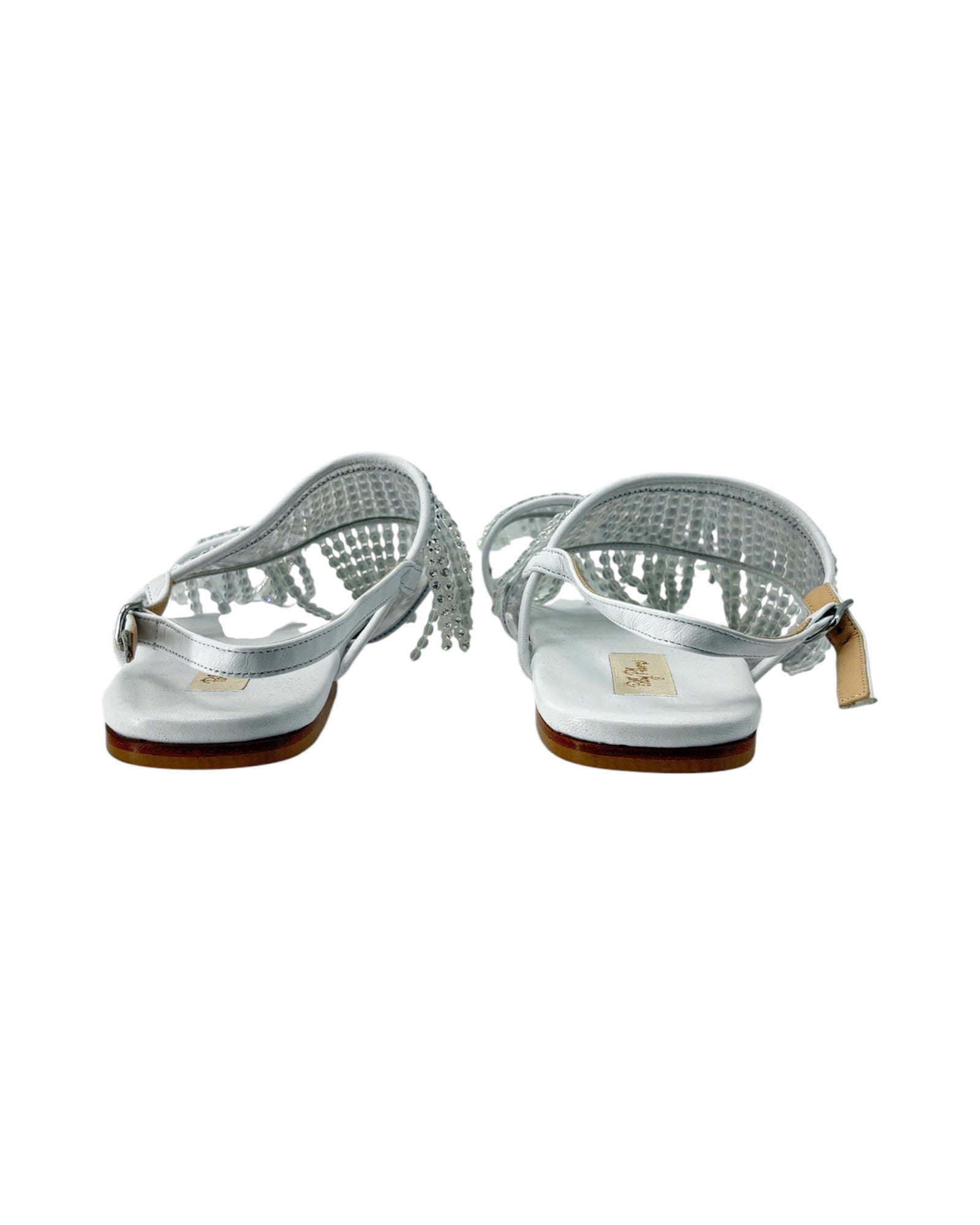Pair of silver sandals with a white sole on a white background