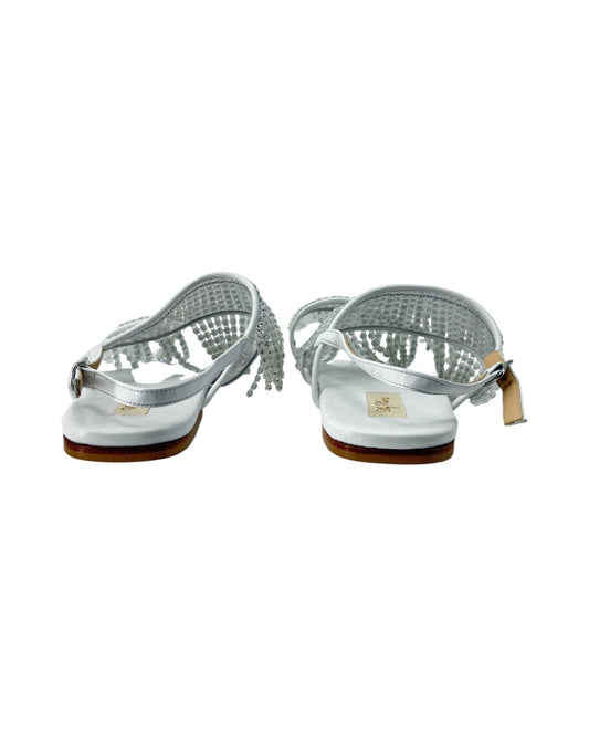 Pair of silver sandals with a white sole on a white background