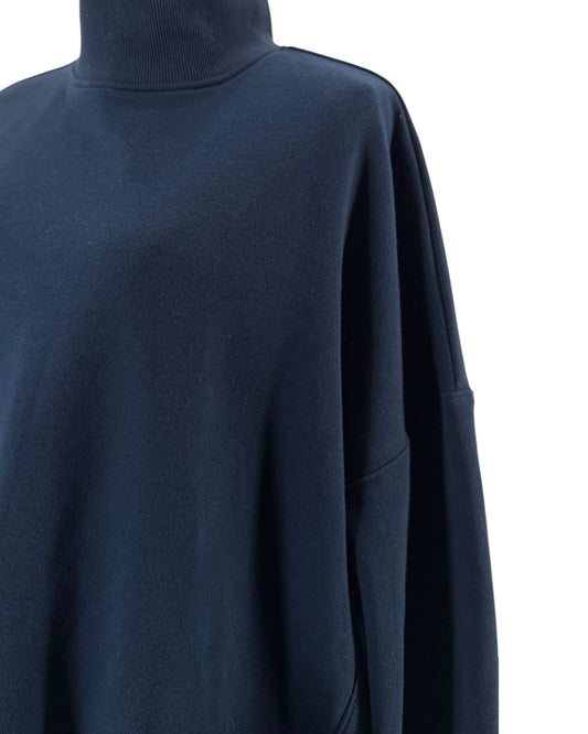 Navy oversized silhouette, high mock/turtleneck, long sleeves, two distinctive large patch pockets on the front on a mannequin on a white background