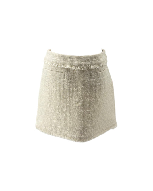 A light beige textured tweed mini skirt with a frayed waistband and front pockets, shown against a plain white background.