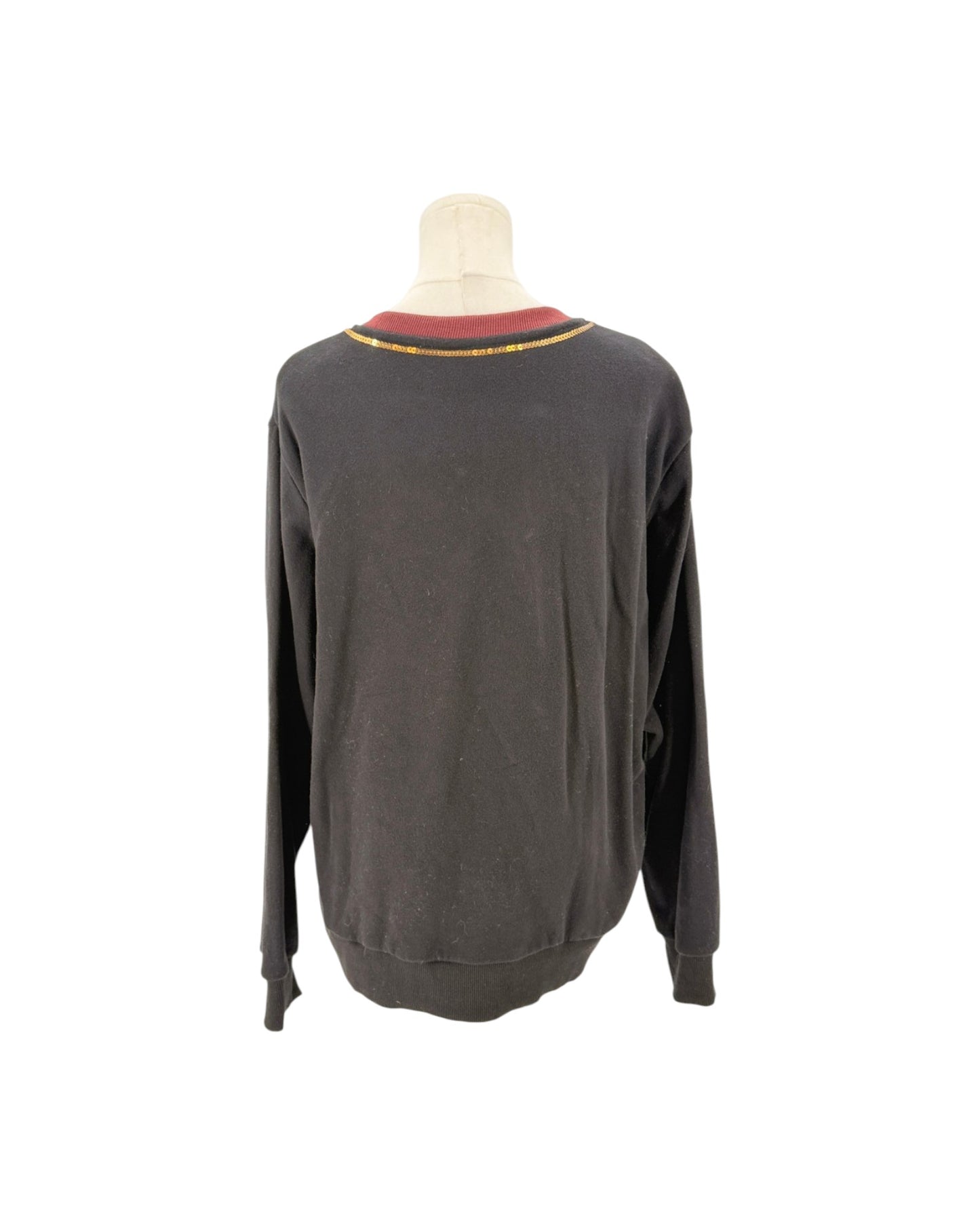 A dark gray long-sleeve crewneck sweater displayed on a mannequin torso, showing a red and yellow striped collar trim.