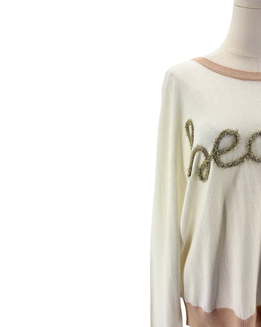 White sweater with decorative text on a mannequin against a white background