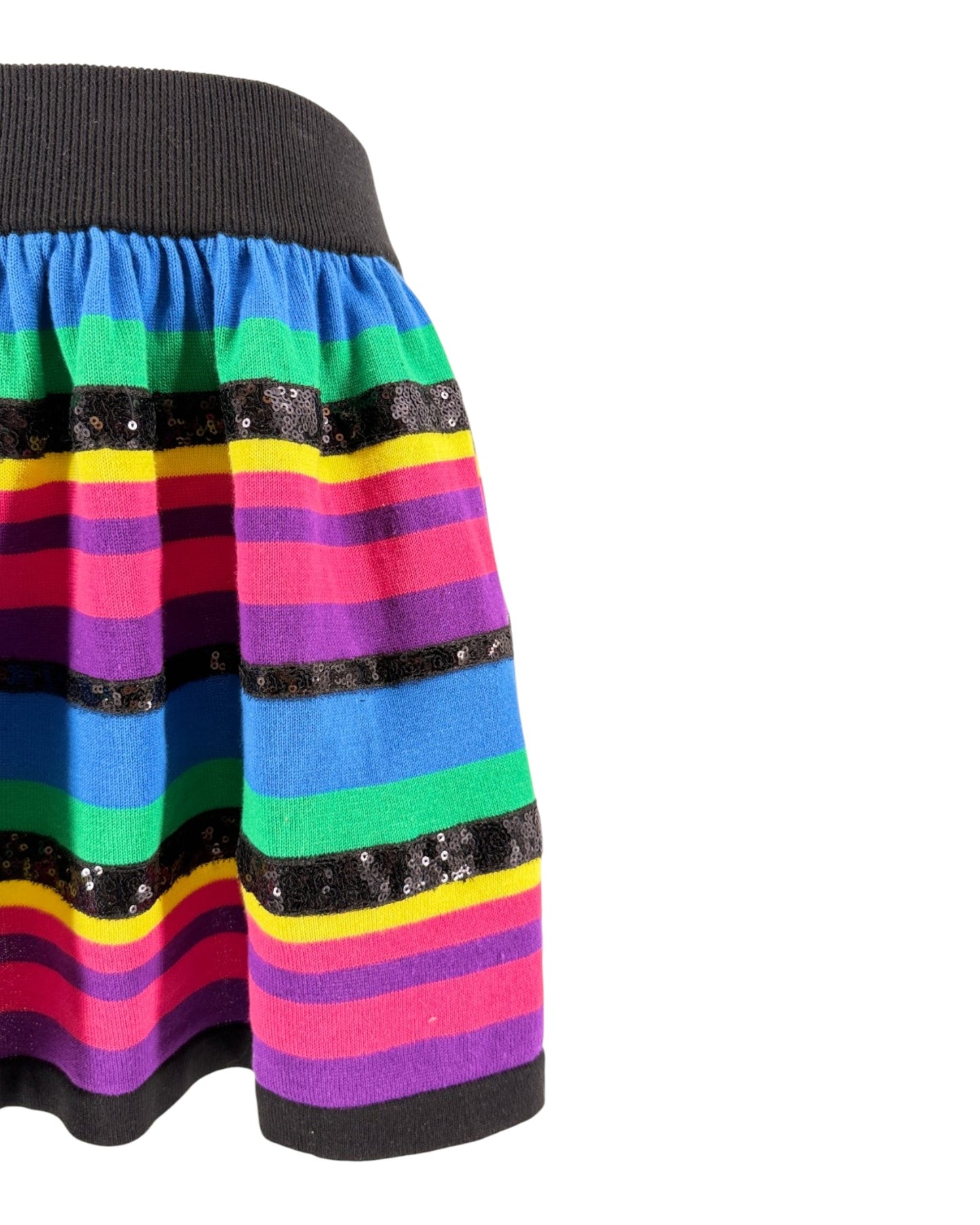 A close-up of a colorful striped skirt with horizontal bands of blue, green, yellow, pink, purple, and black sequined trim, shown against a plain white background.
