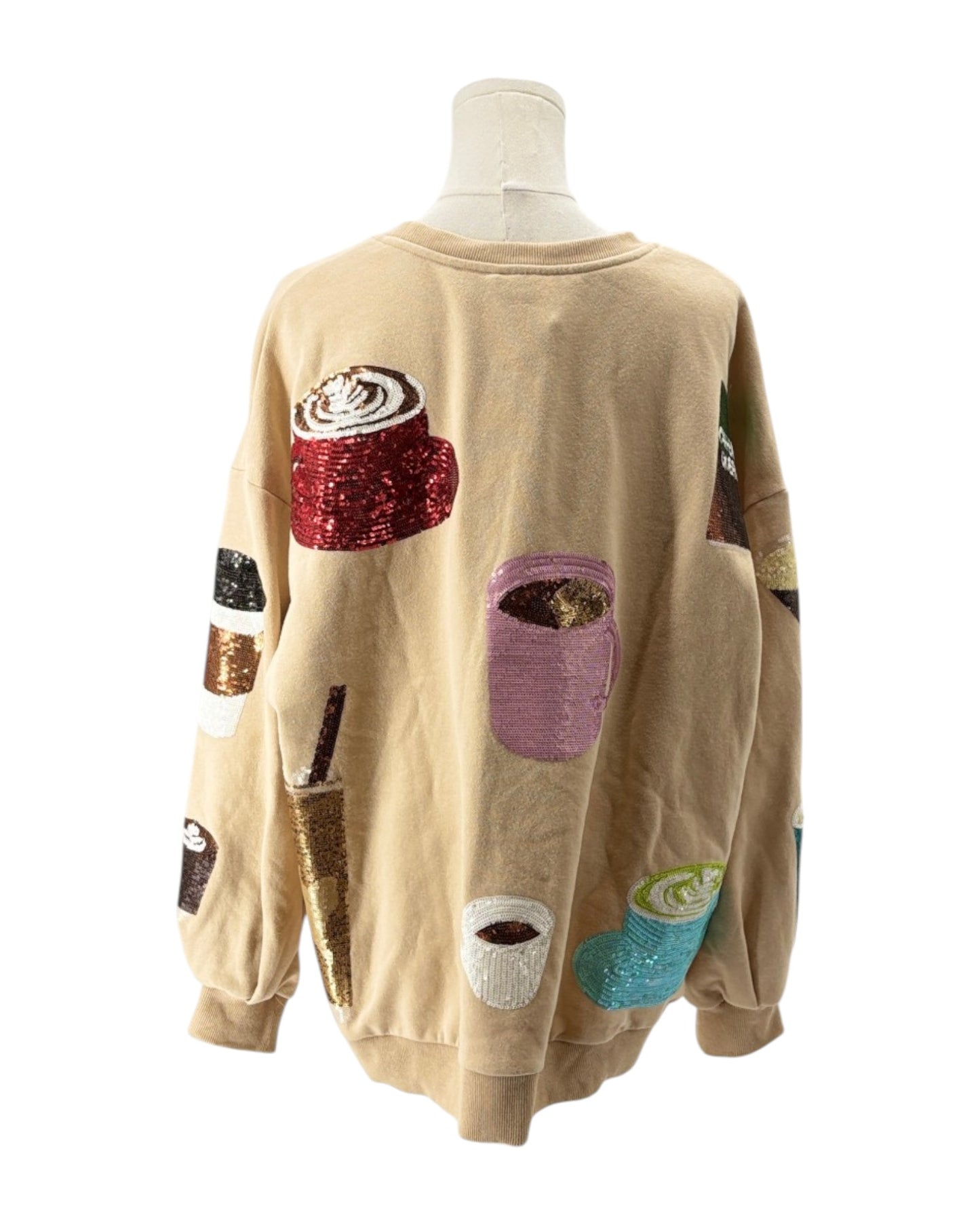 Beige sweatshirt with colorful coffee-themed patches on a mannequin against a white background