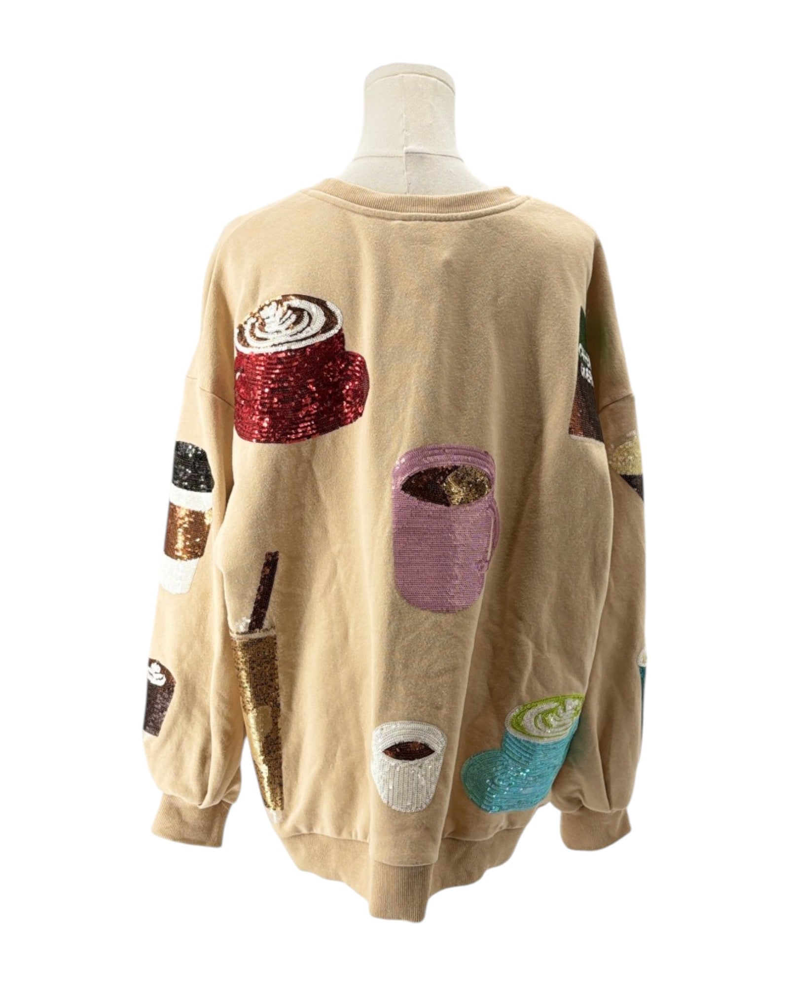 Beige sweatshirt with colorful coffee-themed patches on a mannequin against a white background