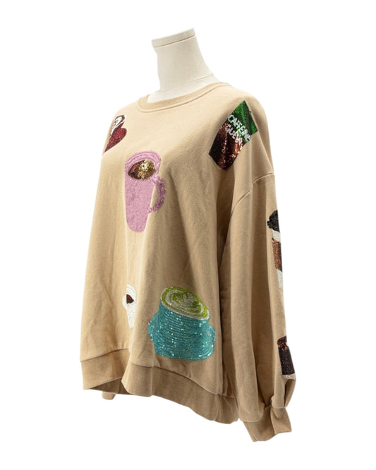 Beige sweatshirt with colorful patches on a mannequin against a white background