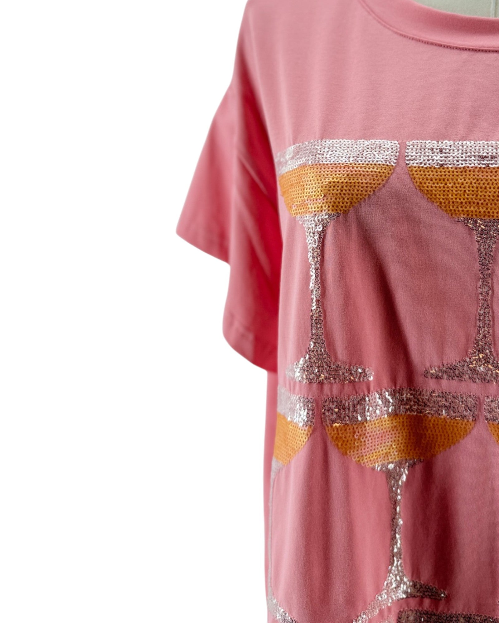 Pink t-shirt with sequin wine glass design on a white background