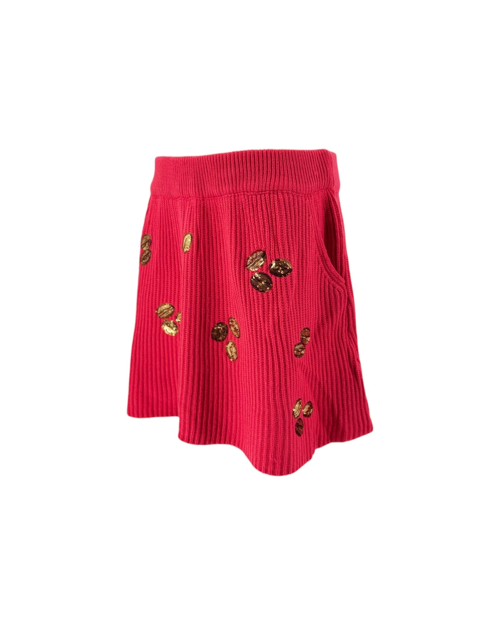 A bright pink ribbed knit skirt with pockets and small gold sequin embellishments, shown against a plain white background.
