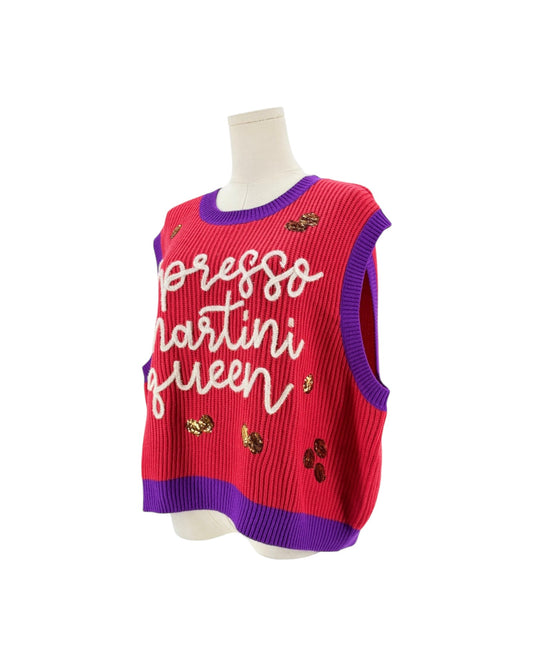 A sleeveless ribbed knit sweater vest in bright pink with purple trim, featuring white cursive text reading 'expresso martini queen' and small embroidered cherry motifs, displayed on a mannequin torso against a white background.