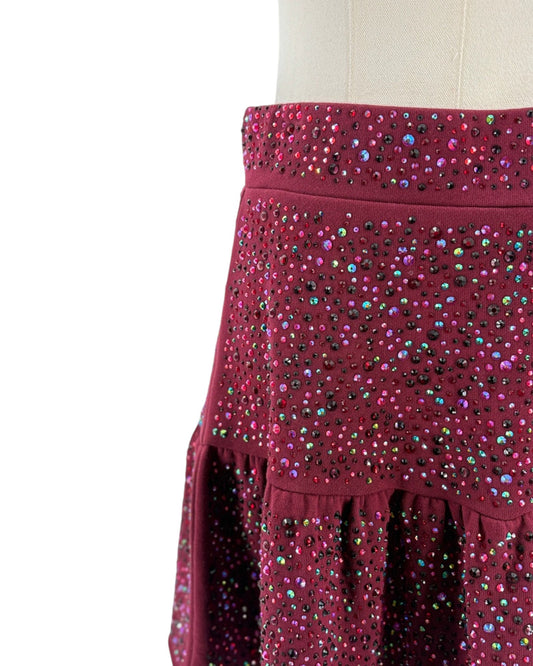 Maroon skirt with colorful embellishments on a mannequin against a white background