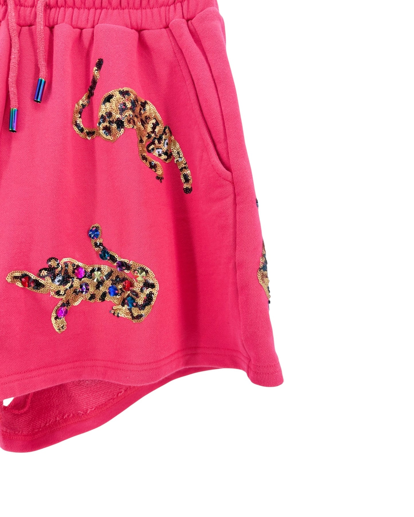 Bright pink children's shorts featuring sequined leopard prints in gold, black, and multicolor rhinestones, with a matching pink drawstring waistband.